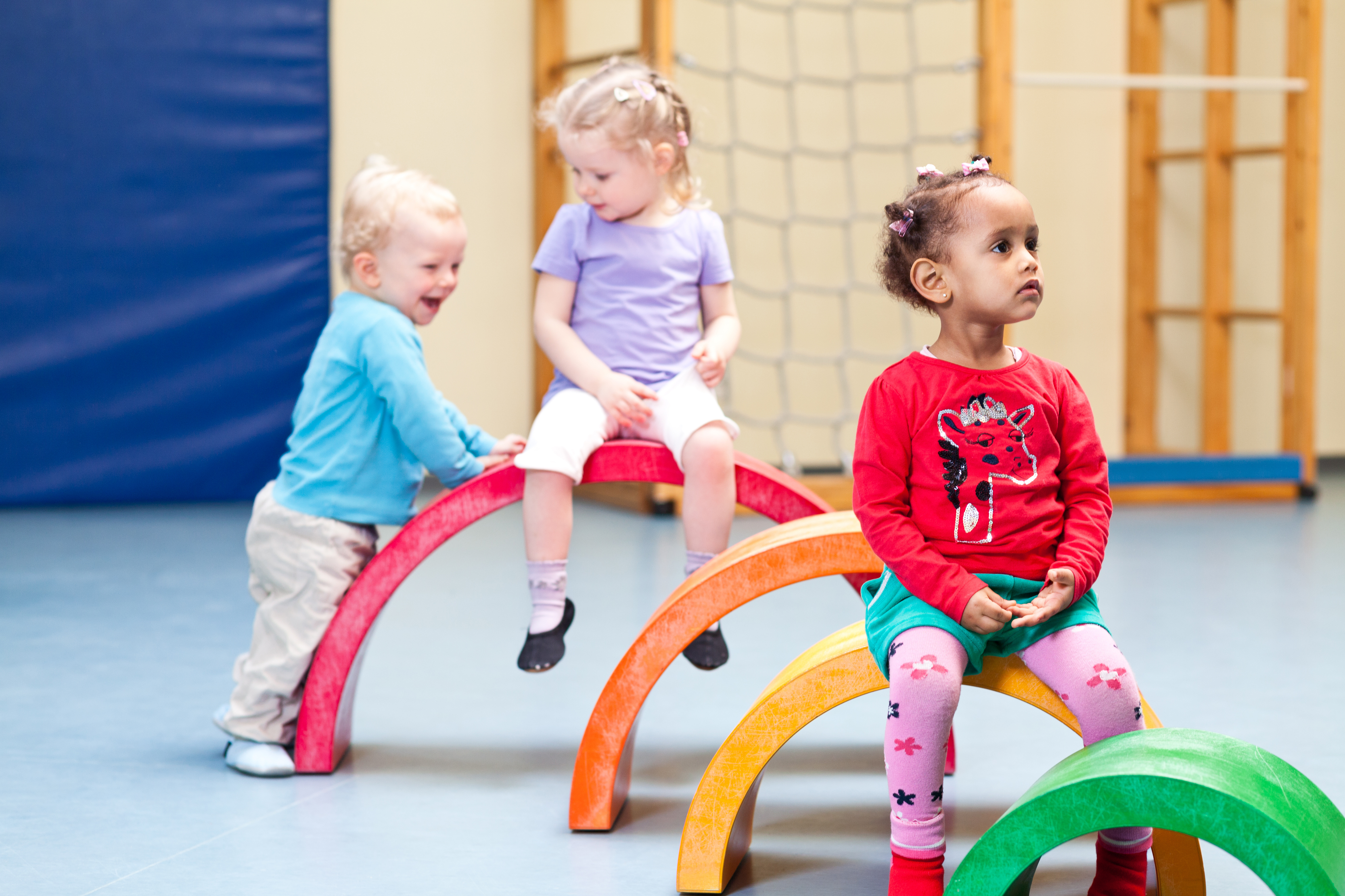 Vier Kinder spielen an Turngeräten.