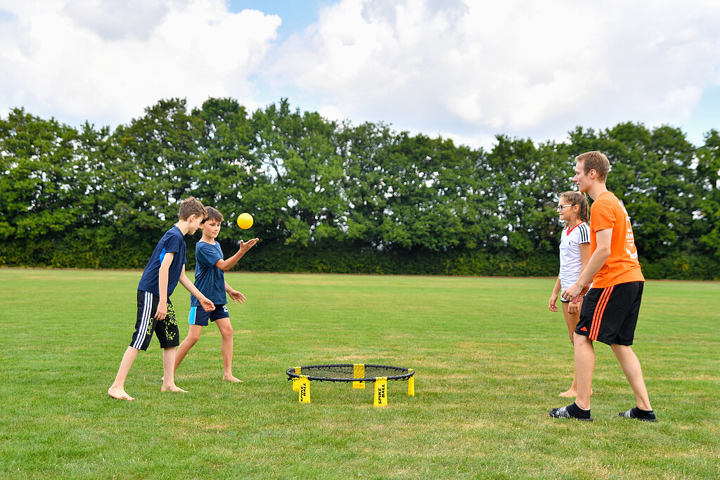 Eine Gruppe Kinder spielt Spike-Ball. 