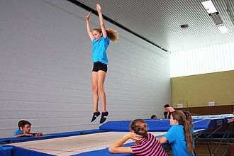 Jugendliche auf und neben dem Trampolin.