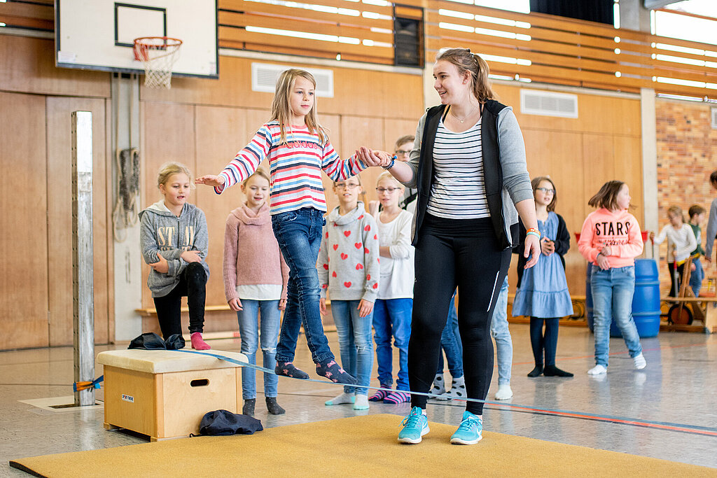 Trainerin mit Kindern in der Halle.