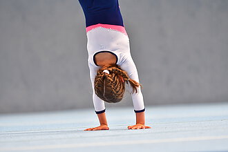 Ein Mädchen macht einen Handstand.