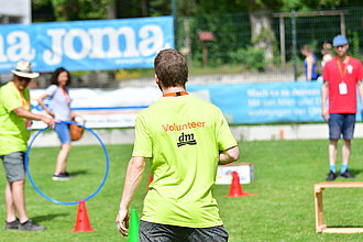 Ein junger Mann von hinten mit der T-Shirt Aufschrift "Volunteer".