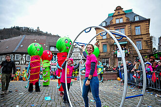 Ein bunter Festumzug mit vielen Teilnehmenden durch eine Altstadt.