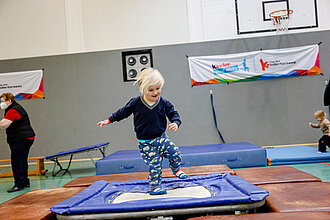 Ein Kind springt auf einem kleinen Trampolin.