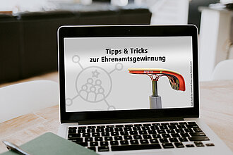 Laptop mit der Aufschrift "Tipps & Tricks zur Ehrenamtsgewinnung"