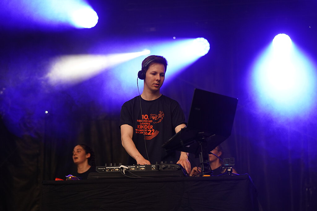 Ein DJ steht auf einer Bühne.