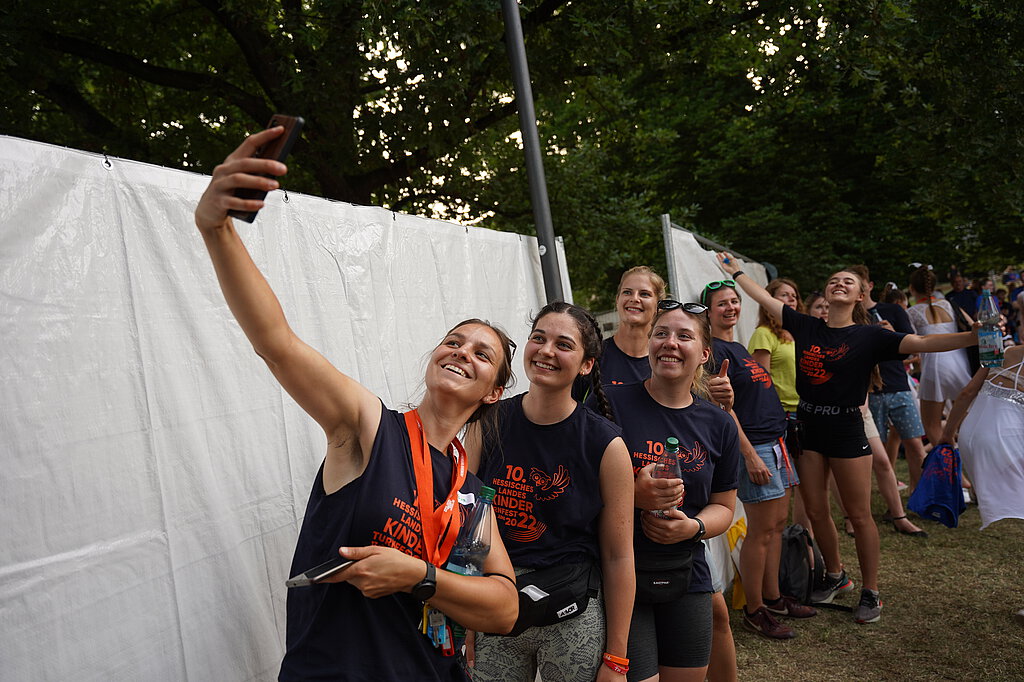 Das Team des letzten Landeskinderturnfest macht ein Gruppenfoto mit dem Handy
