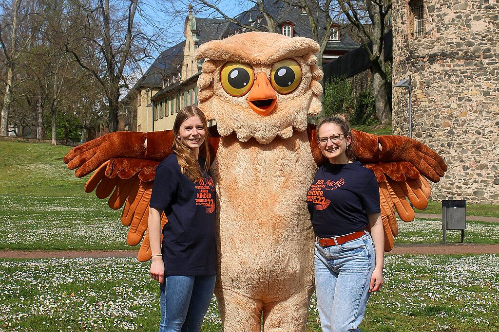 Das Maskottchen des Landeskinderturnfests hat die beiden HTJ-Vorsitzenden im Arm.