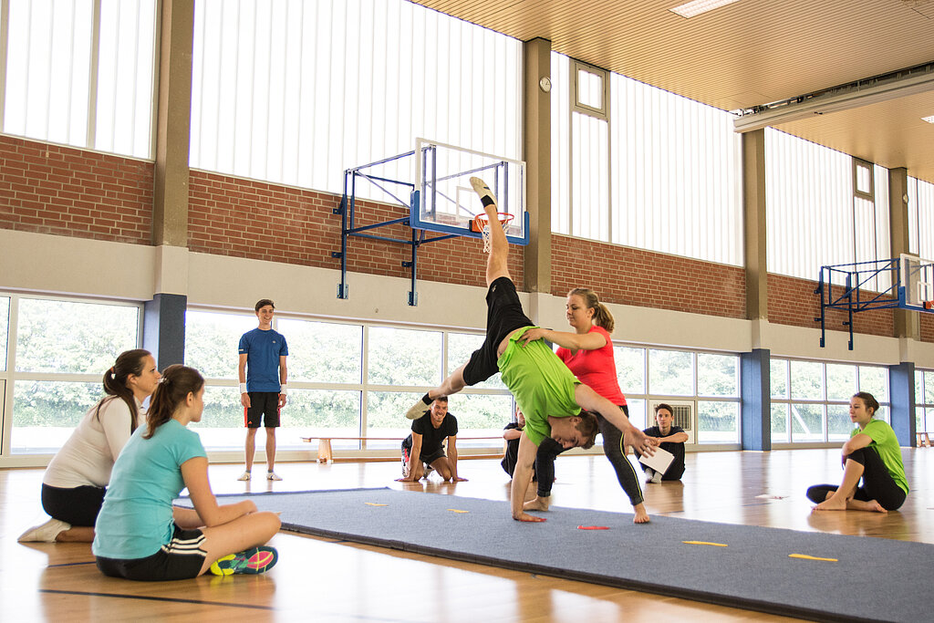 Jugendliche turnen in der Halle.