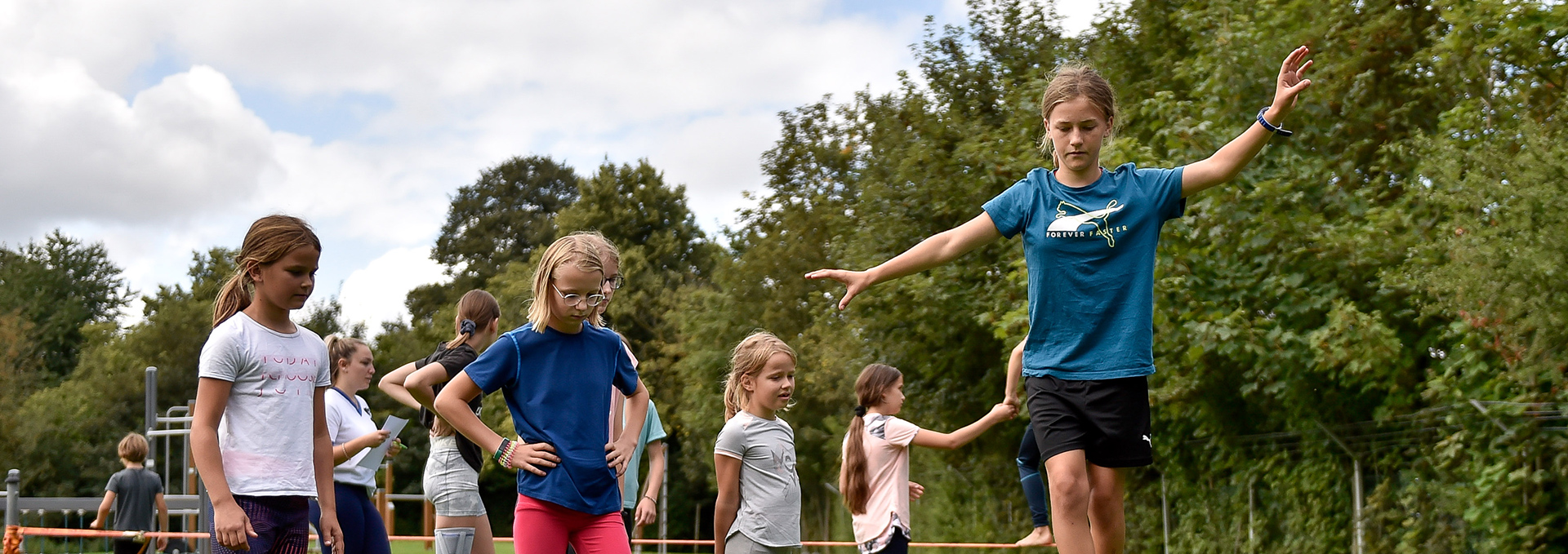 Viele Kinder balancieren und spielen draußen.