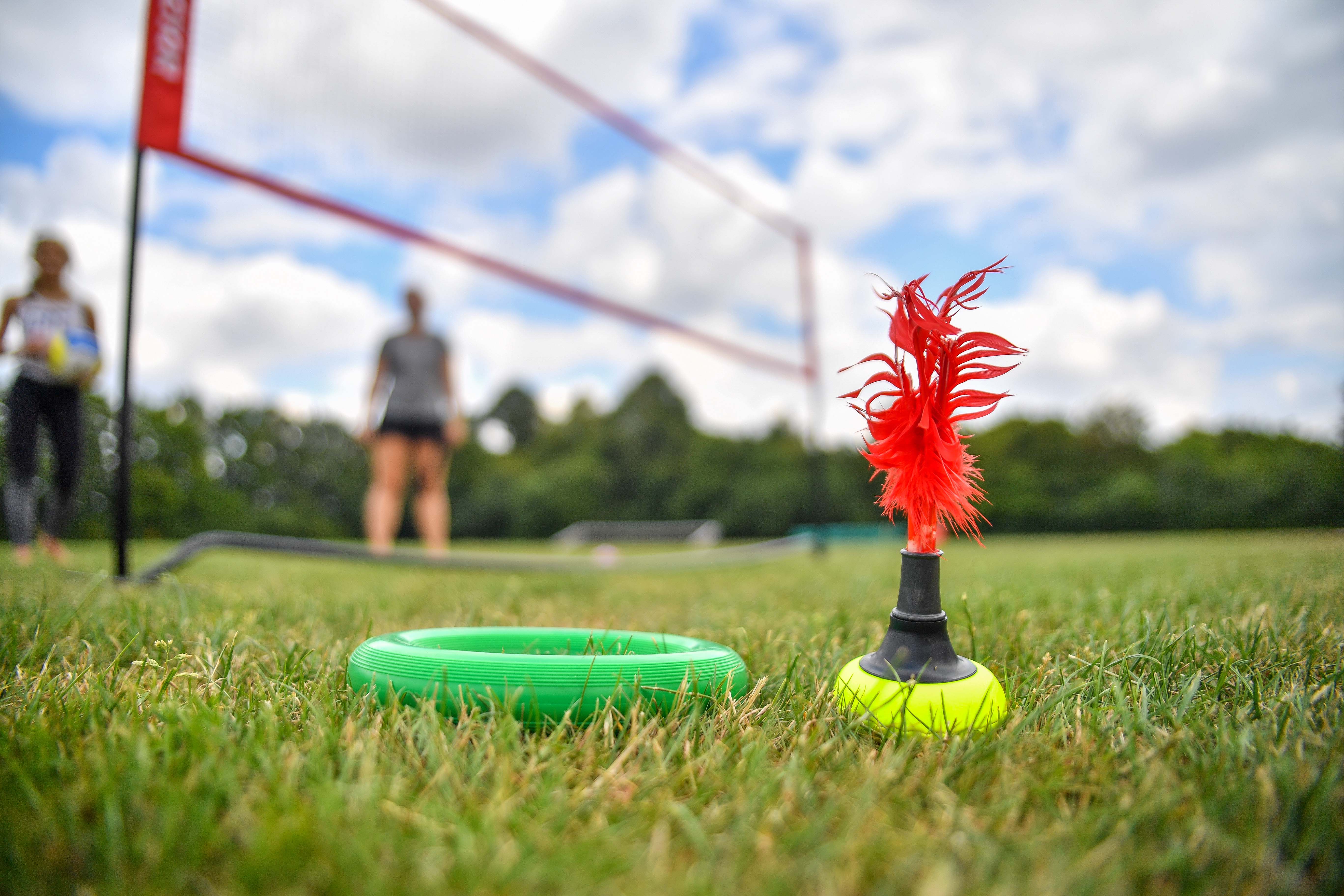 Wurfgeräte liegen vor einem Volleyballnetz im Gras