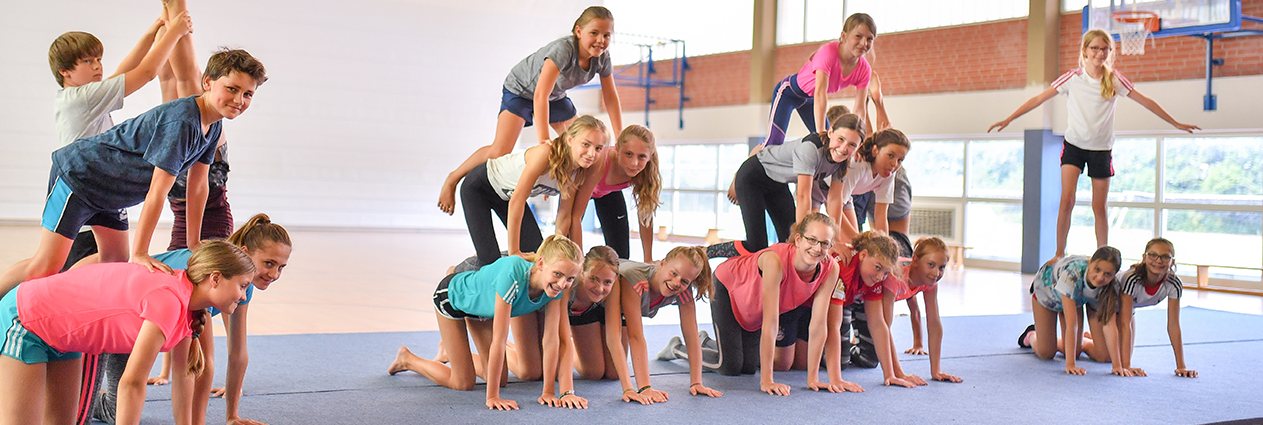 Schulkinder machen zusammen Akrobatik.