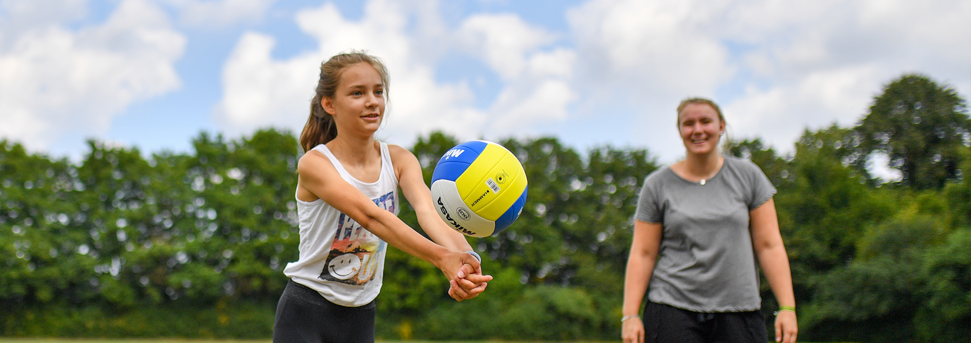 Zwei Mädchen spielen Volleyball.