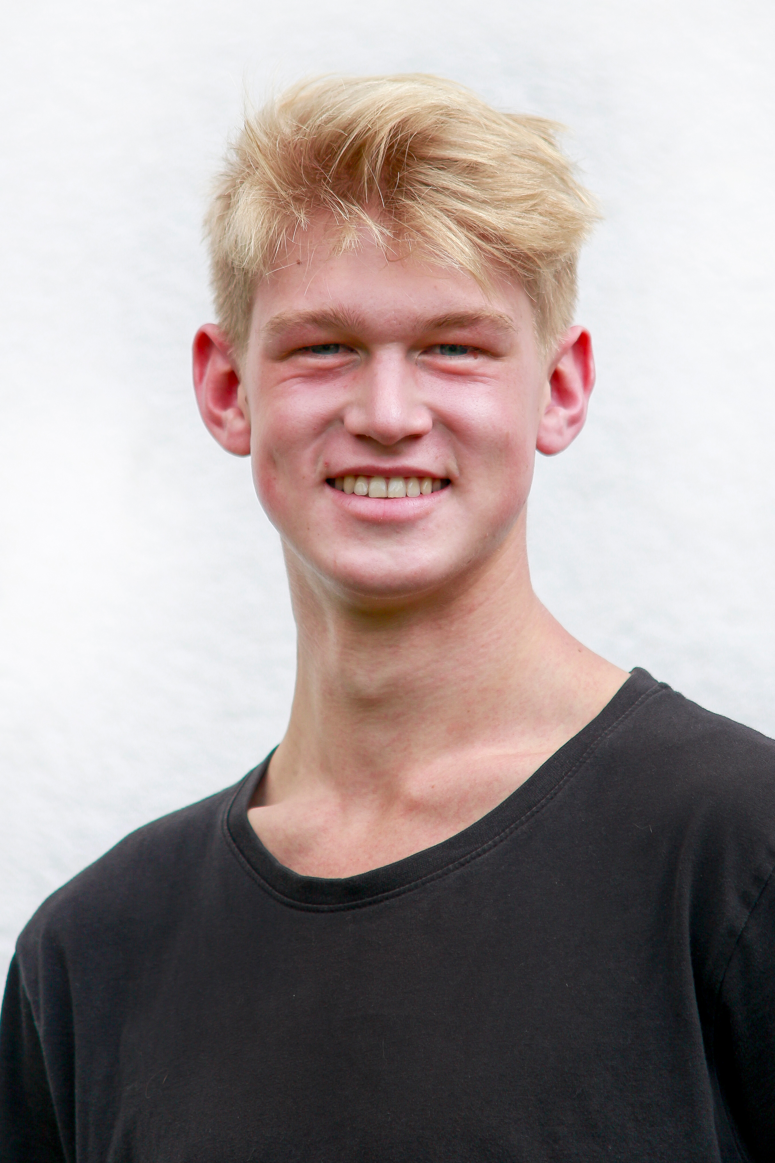 Ein blonder Mann lacht in die Kamera.